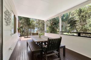 a dining room with a table and chairs on a balcony at Salty Beach in Amity Point