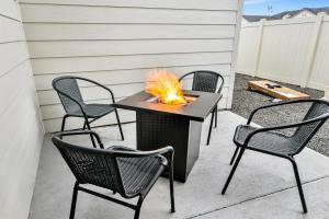 a fire pit on a patio with four chairs at Highland Haven by Settler's Park in Meridian