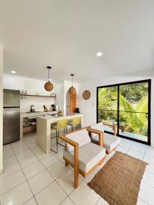 a kitchen and living room with a table and chairs at Encantador Loft con Piscina 1 BDR in Santa Teresa Beach
