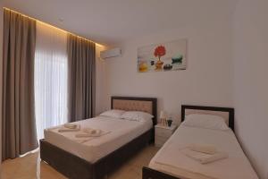 a bedroom with two beds and a window at Vila Feimi in Ksamil