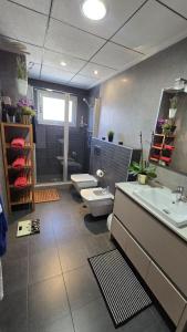 ein Badezimmer mit zwei Waschbecken, Toilette und Dusche in der Unterkunft De paso in Albatera