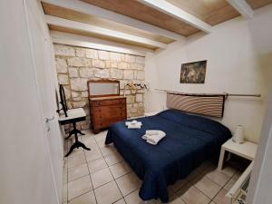 a bedroom with a blue bed with towels on it at Appartamento in Centro casa vacanza in Scicli