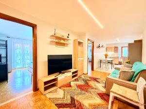 a living room with a couch and a television at Casa di Mary in Châtillon