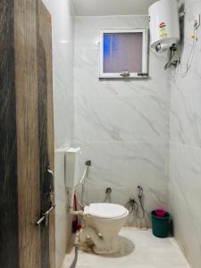 a bathroom with a toilet and a window at Sanatan lok in Ujjain