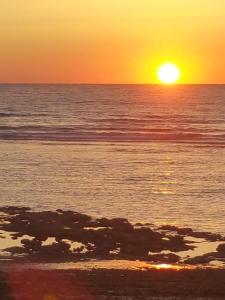 a sunset over the ocean with the sun setting at Dar Moussa Assilah in Asilah +31 photos