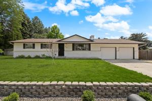 a house with a large yard with a driveway at Poolside Paradise with Hot Tub in Boise