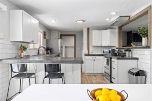 a kitchen with white cabinets and a bowl of oranges at Poolside Paradise with Hot Tub in Boise