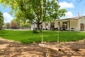 a swing in a yard next to a house at Poolside Paradise with Hot Tub in Boise