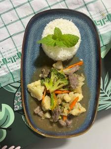 a plate of food with meat and vegetables and rice at Manatini lodge in Faie