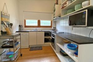 a kitchen with white cabinets and a counter top at Saltys Amity Point in Amity Point +3 photos