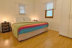 a bedroom with a bed with a colorful blanket at Saltys Amity Point in Amity Point