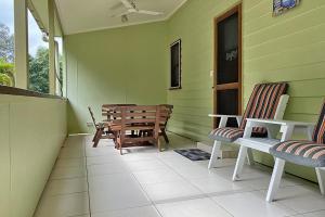 a porch of a green house with chairs and a table at Saltys Amity Point in Amity Point
