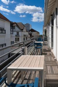 a deck with benches and tables on a building at Marnie House in Le Touquet-Paris-Plage
