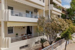 an apartment building with a balcony and trees at Captain's Corner in Markopoulo