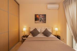 a bedroom with a large bed with two lamps at Captain's Corner in Markopoulo