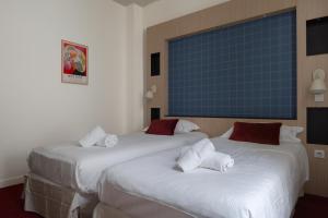 two beds in a hotel room with white sheets at Marnie House in Le Touquet-Paris-Plage +26 photos