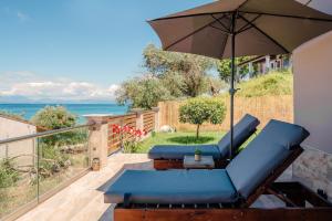 a patio with a blue couch and an umbrella at Villa Margarita in Nótos
