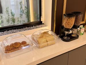 a counter with two plastic containers of bread and a blender at 호텔 꿀밤스테이 in Sacheon