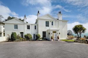 a large white house with a large driveway at Woodend Seaside Villa in Torquay
