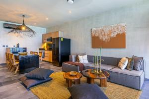 a living room with a couch and a kitchen at Luxury Beachfront 3BR Apt 102 | Neea Bahia Soliman in Balcheil