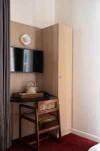 a hotel room with a desk and a television at Marnie House in Le Touquet-Paris-Plage