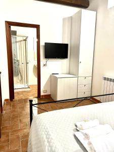 a bedroom with a bed and a tv and a mirror at Le Saliscalette in Norcia
