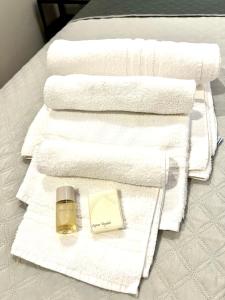a pile of towels and a bottle of perfume on a bed at Le Saliscalette in Norcia