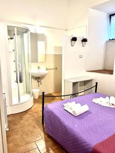 a bathroom with a purple bed with towels on it at Le Saliscalette in Norcia +2 photos