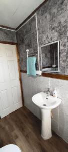 a bathroom with a white sink and a mirror at Cabañas Maullin in Maullín