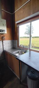 a kitchen with a sink and a window at Cabañas Maullin in Maullín