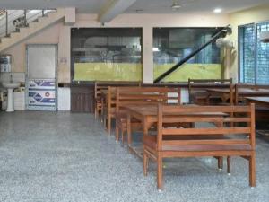a row of wooden benches in a room at Chouhan Resort in Katihār