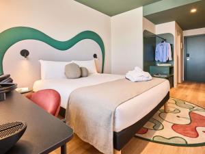 a hotel room with a bed and a table at Ibis Styles Madrid Airport Valdebebas in Madrid