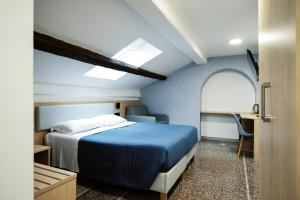a bedroom with a bed and a chair in a room at Hotel Caffaro in Genoa