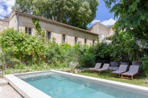 a swimming pool in the yard of a house at Mas de charme - T2 et chambres d'hôtes avec piscine & jardin in Marsillargues