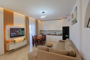 a living room with a couch and a kitchen at Vila Feimi in Ksamil