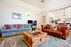 a living room with two couches and a coffee table at Woodend Seaside Villa in Torquay