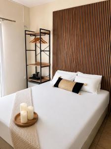a bedroom with a large white bed with two candles at Aurelia Rooms in Ios Chora