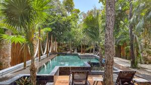 an outdoor pool with palm trees and chairs at Amaka Calma Tulum by Cercana in Tulum +29 photos