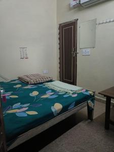a bed in a room with a blue blanket on it at Gopal Sadan-2 in Vrindāvan +5 photos