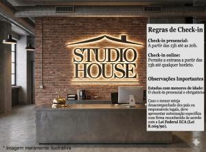 ein Schild für ein Atelierhaus an einer Backsteinmauer in der Unterkunft Studio House in São Paulo