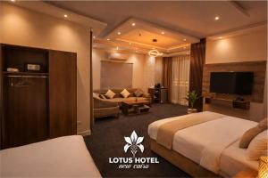 a hotel room with two beds and a couch at Lotus Hotel - Golden Square in Cairo