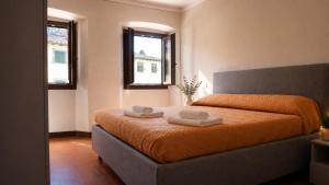 a bedroom with a bed with two towels on it at la Pace camere con bagno nel centro storico di Stia in Stia