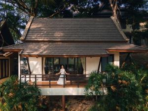 a woman standing on a balcony of a house at Kooncharaburi Resort - Koh Chang in Ko Chang +238 photos