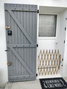 a gray door with a window and a sign in front of it at La Trimouillaise in La Trimouille