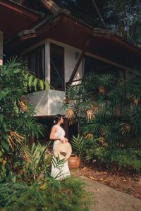 a woman sitting in front of a house at Kooncharaburi Resort - Koh Chang in Ko Chang