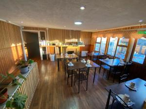 a dining room with tables and chairs in a restaurant at Hostal Ochen in Punta Arenas