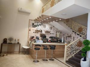 a kitchen with a bar with stools and a staircase at فندق الجادل Al Jadel Hotel in Al Kharj