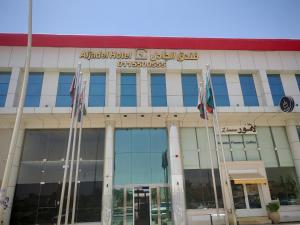an office building with flags in front of it at فندق الجادل Al Jadel Hotel in Al Kharj