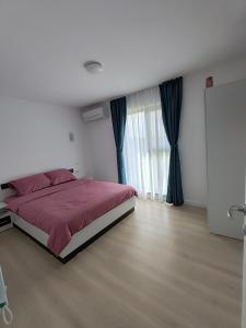 a bedroom with a bed with a red comforter at Cozy apartment Vama Veche in Vama Veche
