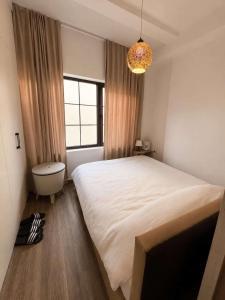 a bedroom with a large white bed and a window at Hotel Berati in Prizren